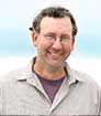 Head shot photo of author John Stansifer smiling and wearing glasses for Mark Malatesta Review